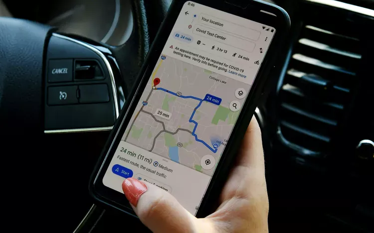 Celular com o mapa de uma rota, preso no painel do carro